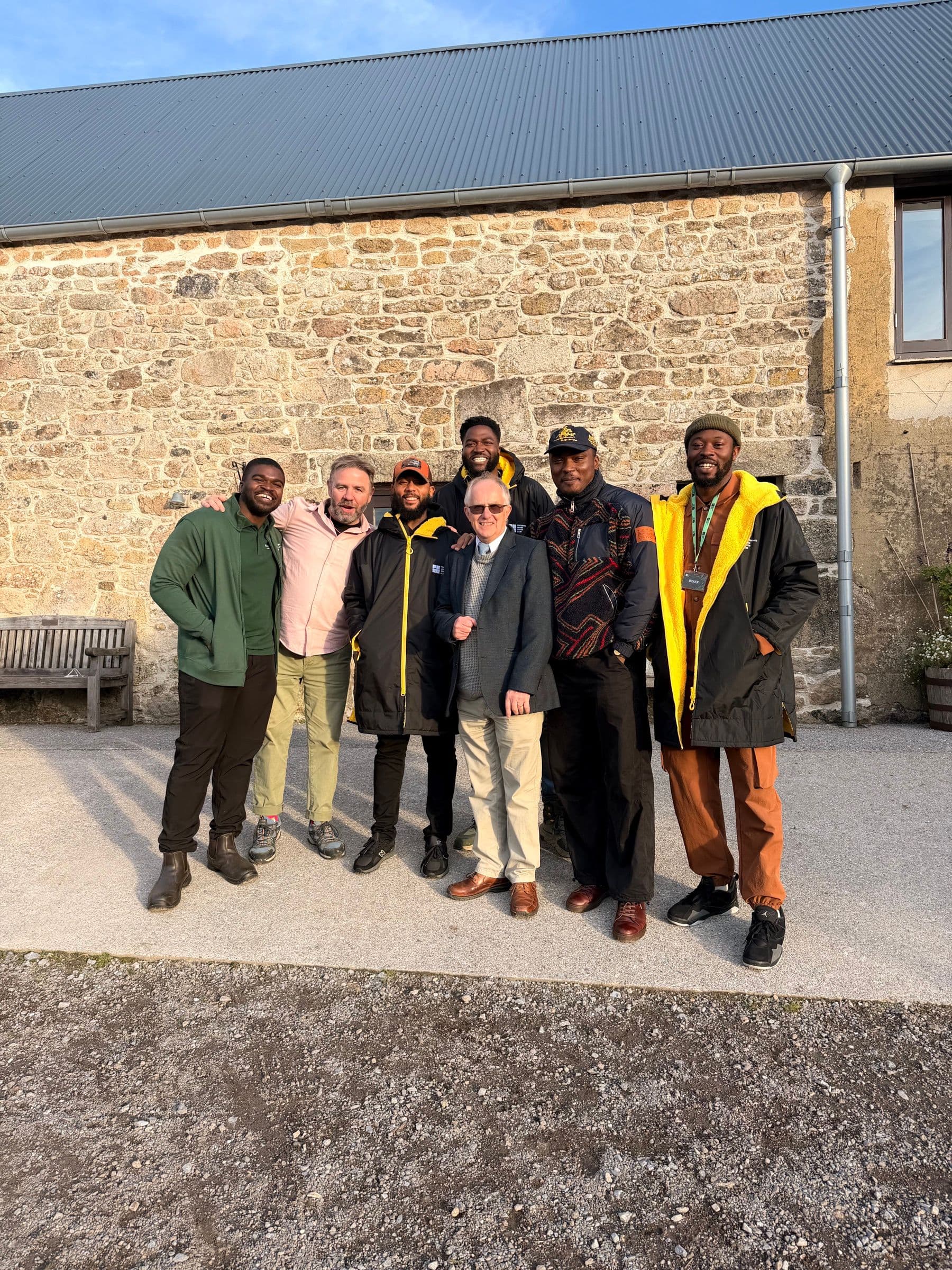 The Providence House team at East Shallowford Farm in Devon, gathered outside a stone barn for the farm's 50th anniversary